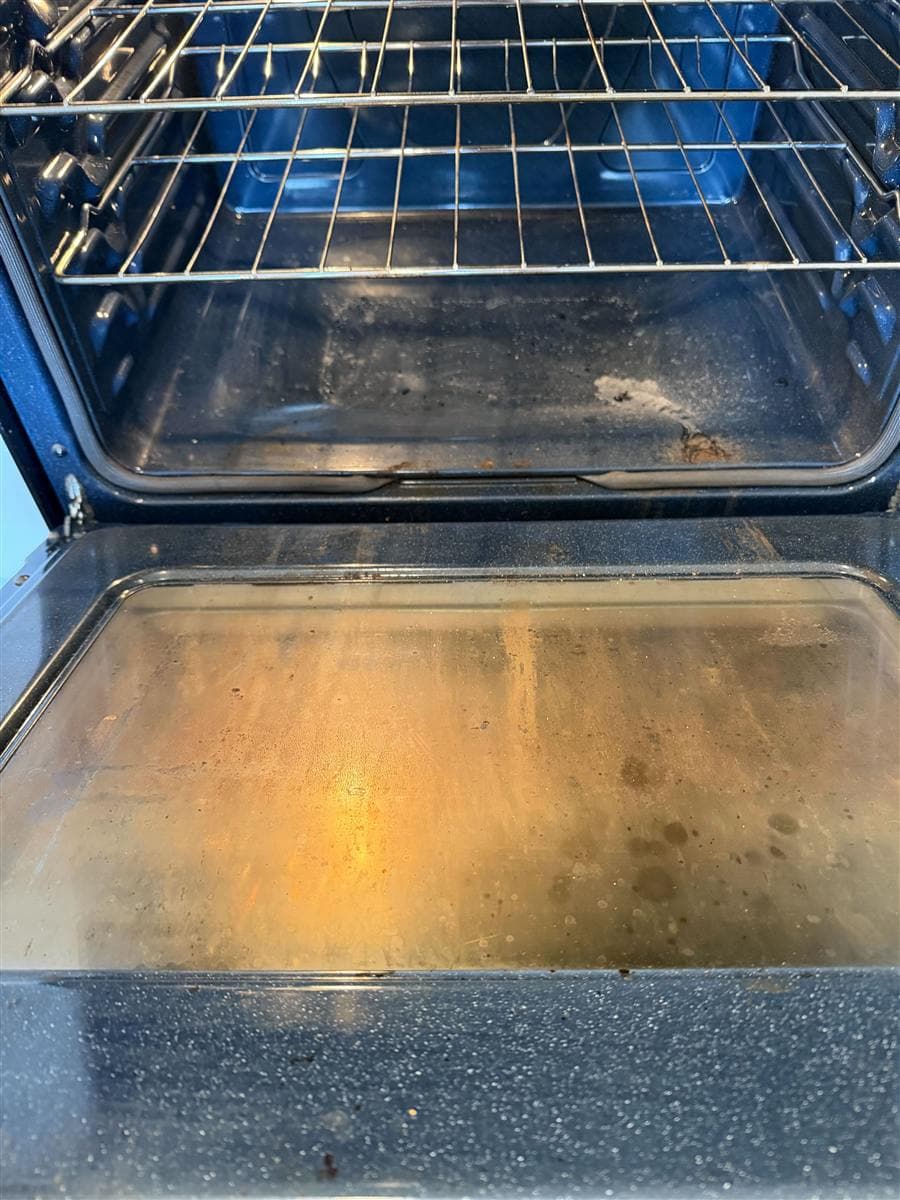 Oven interior covered in heavy baked-on soot and grease before cleaning.