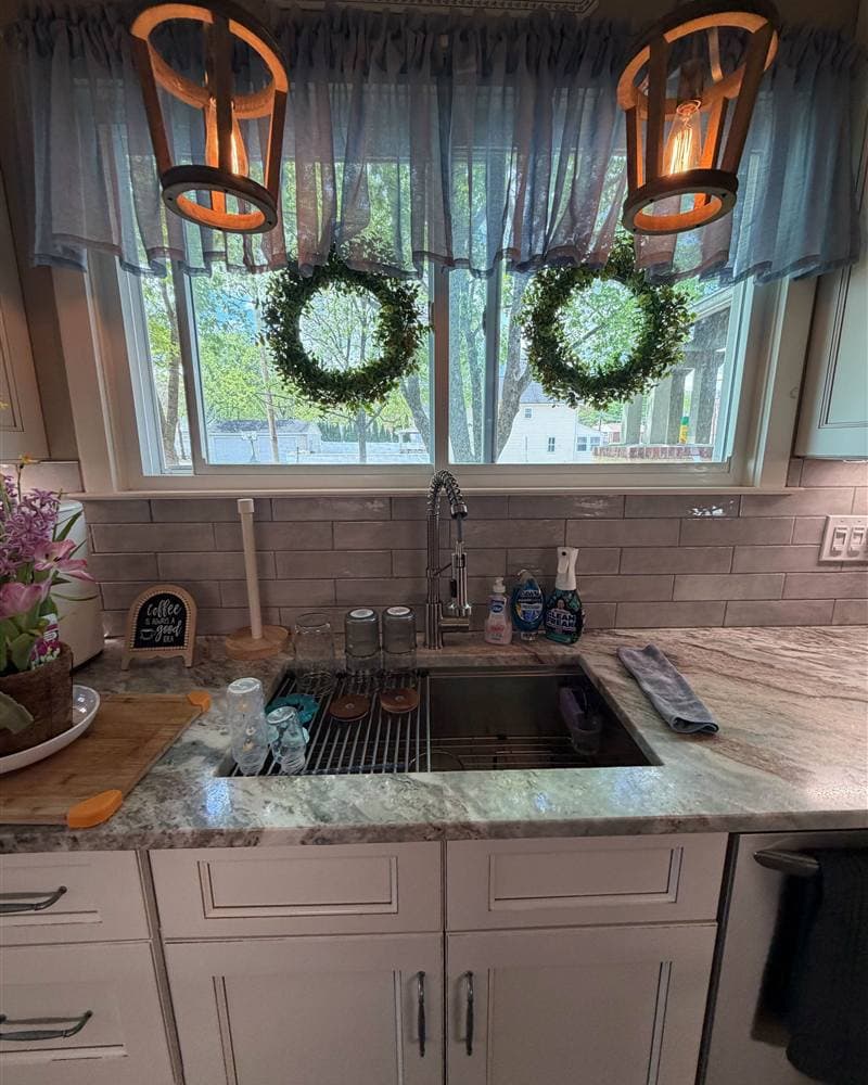 A sunlit farmhouse-style kitchen sink and countertop, spotless after a house cleaning visit in New Jersey.