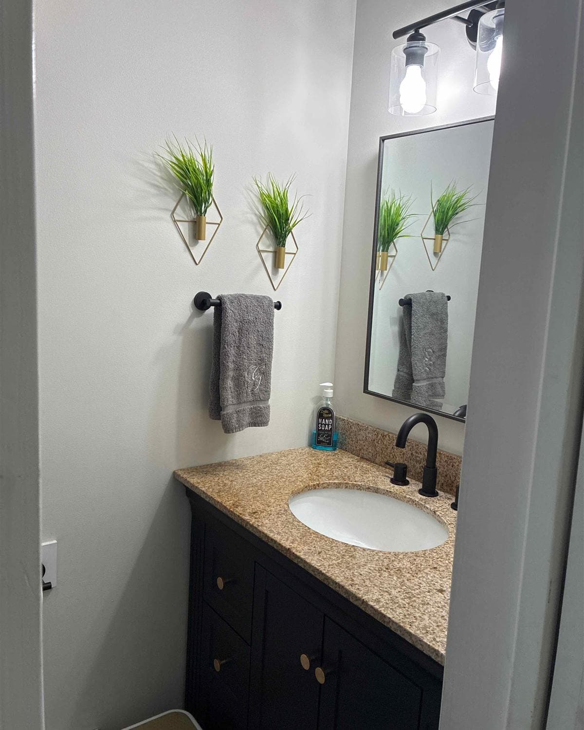 Cleaned bathroom vanity with granite countertop, sink, and mirror after a house cleaning in Boonton, NJ