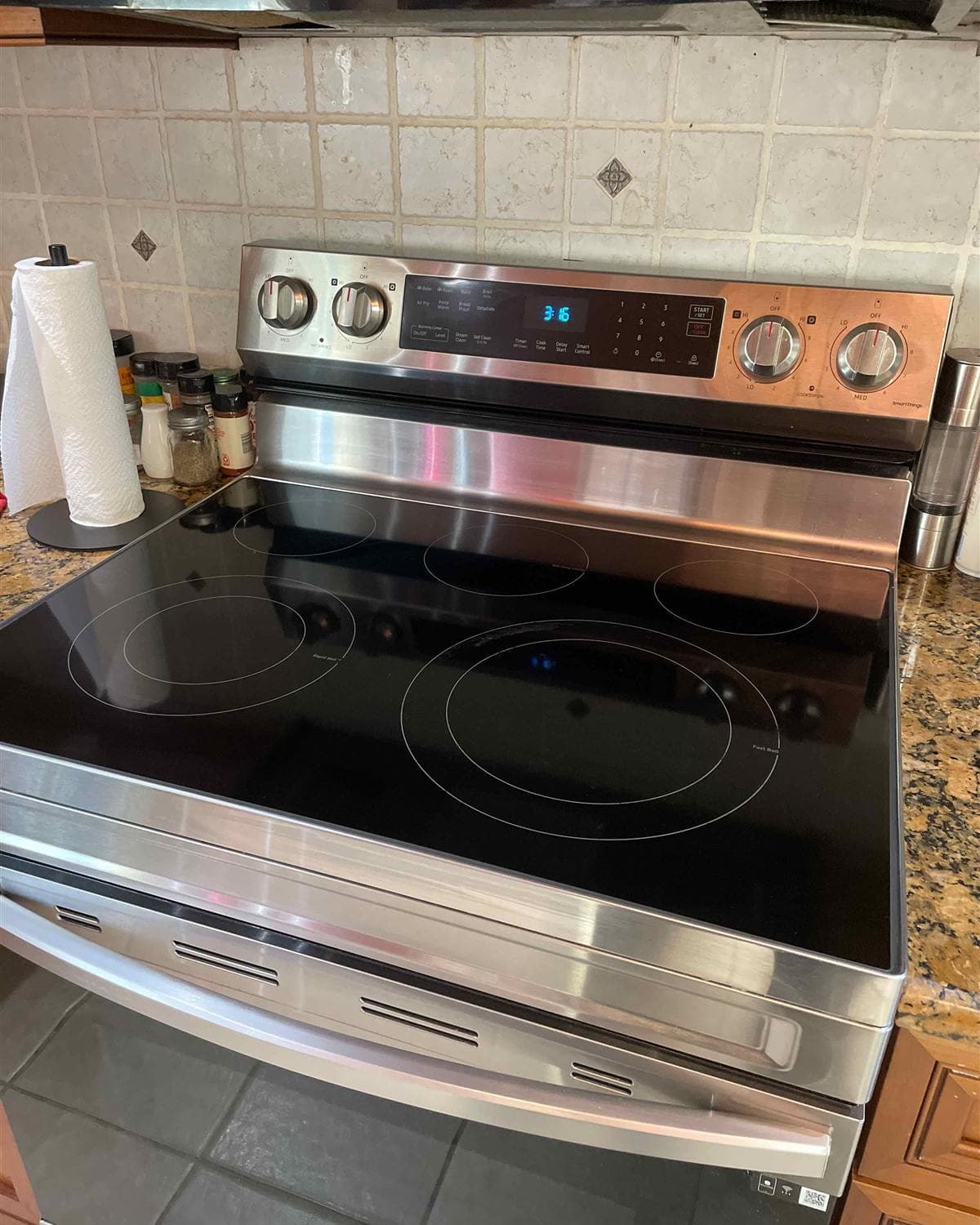 Polished stainless steel range and spotless glass cooktop after a kitchen cleaning in Branchville, NJ