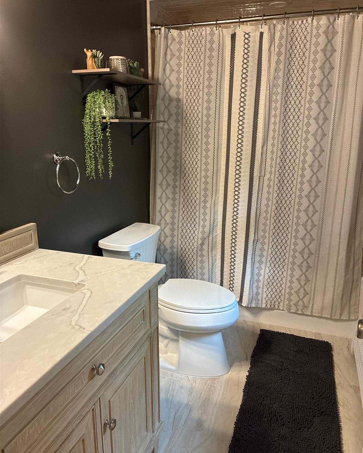Freshly cleaned bathroom with marble-top vanity and patterned shower curtain in Mount Olive, NJ