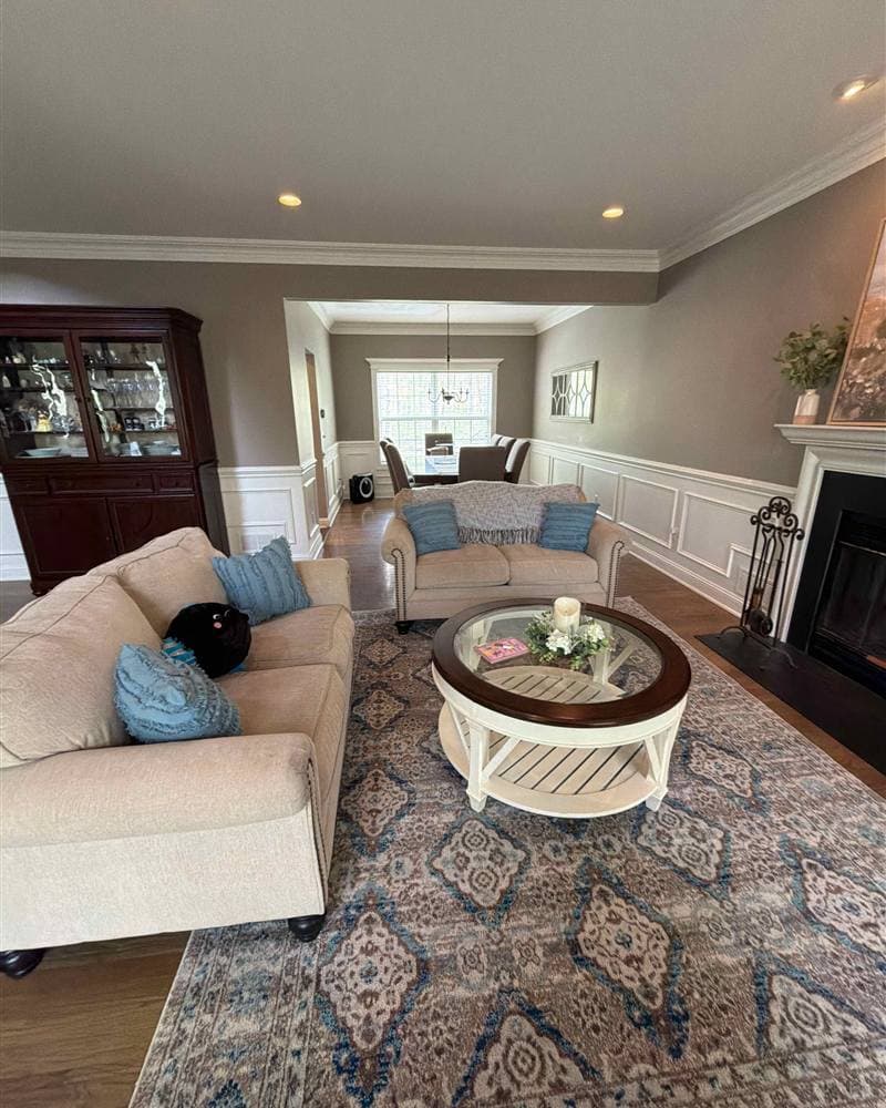 Tidy living room with two sofas, round coffee table, and view into the dining room after cleaning in Rockaway, NJ