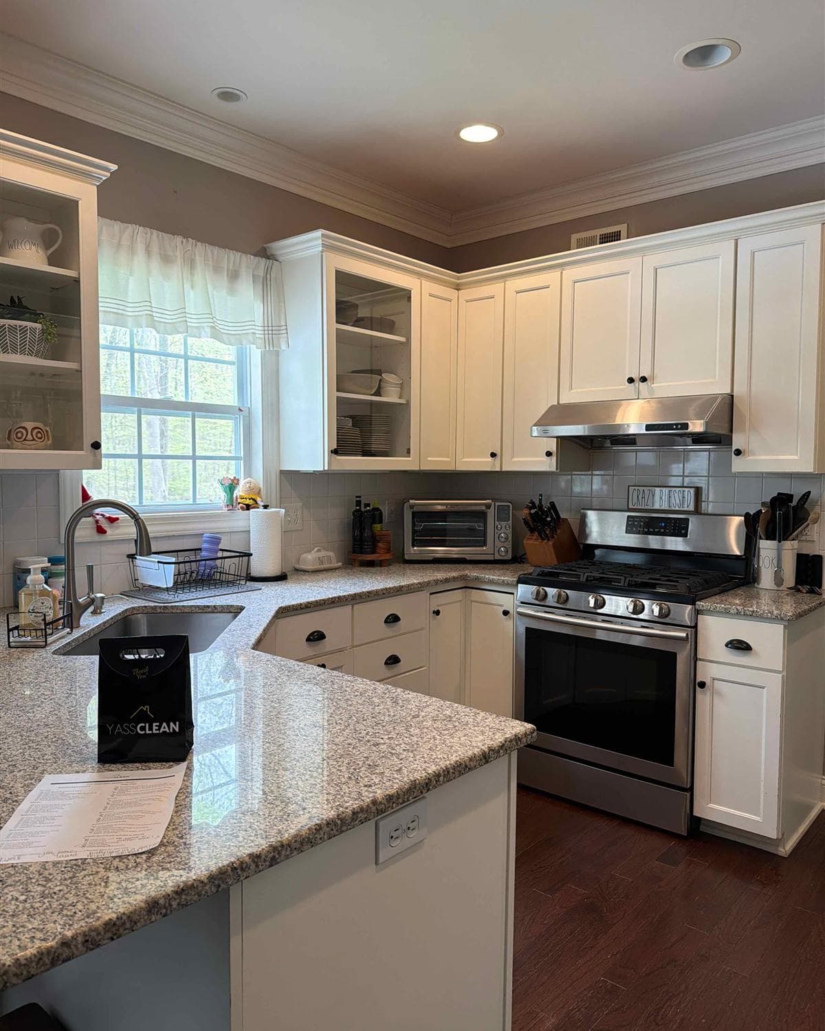 Cleaned kitchen with white cabinets, granite countertops, and stainless steel stove after a YassClean cleaning in Rockaway, NJ