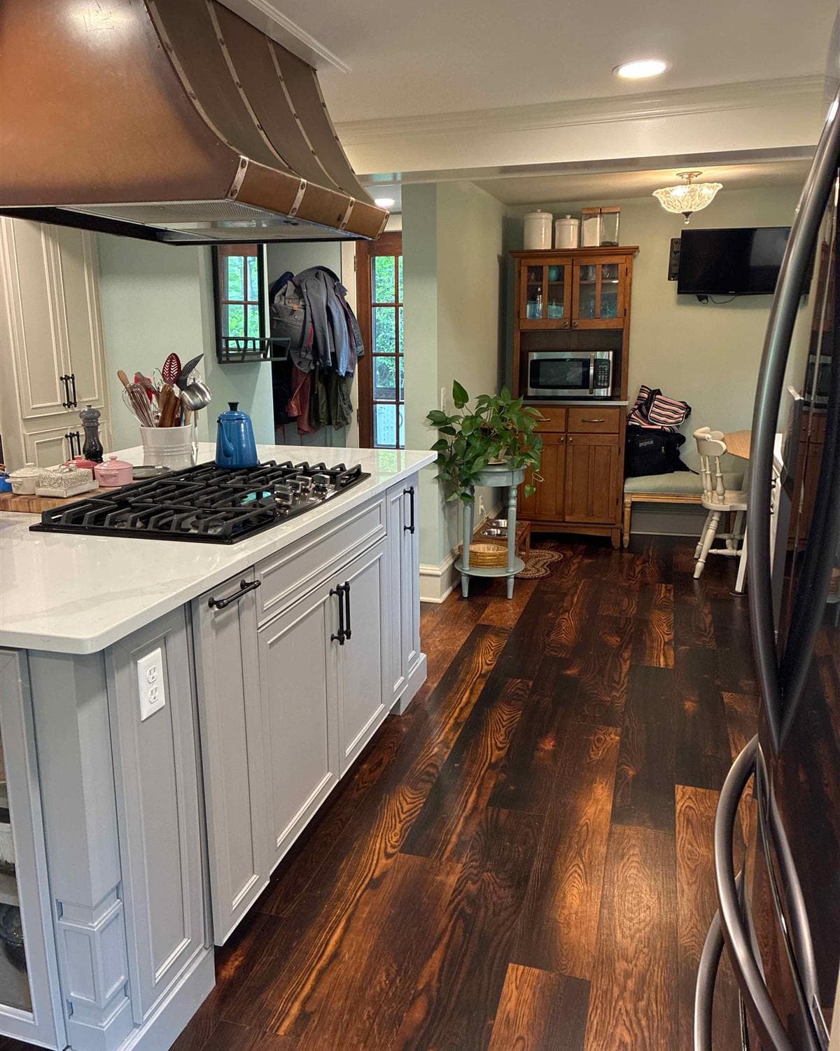 Freshly cleaned kitchen with island gas cooktop and copper range hood in a Sparta, NJ home